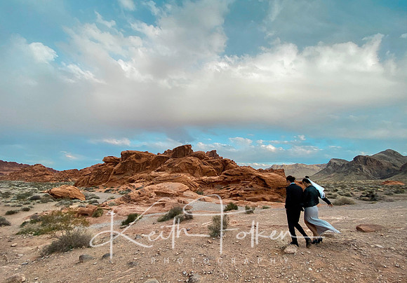 Adam and Eliska walk together with the Valley of Fire rocky background and vast sky
